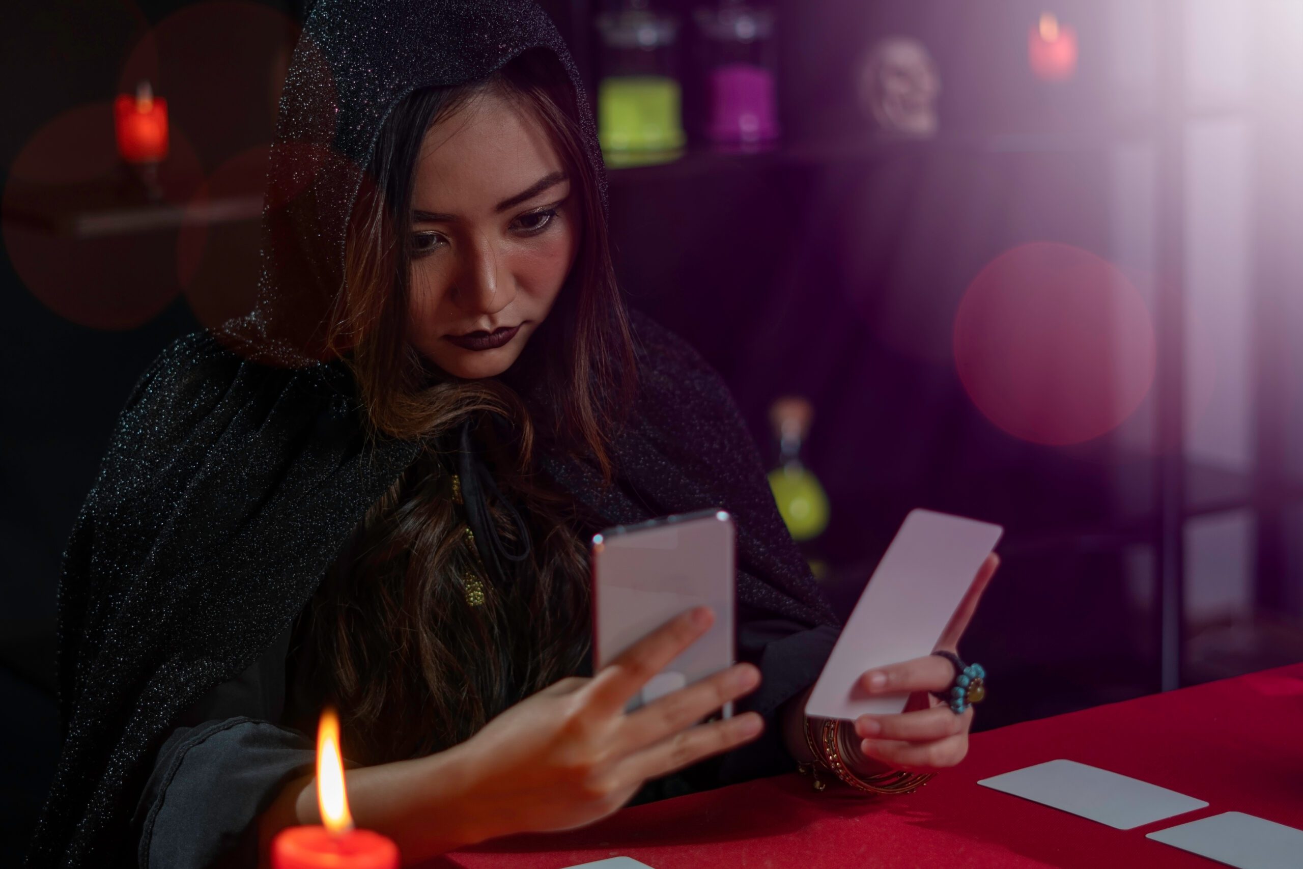 Female fortune teller reads tarot cards for predictions, telling customers by providing services via mobile phones