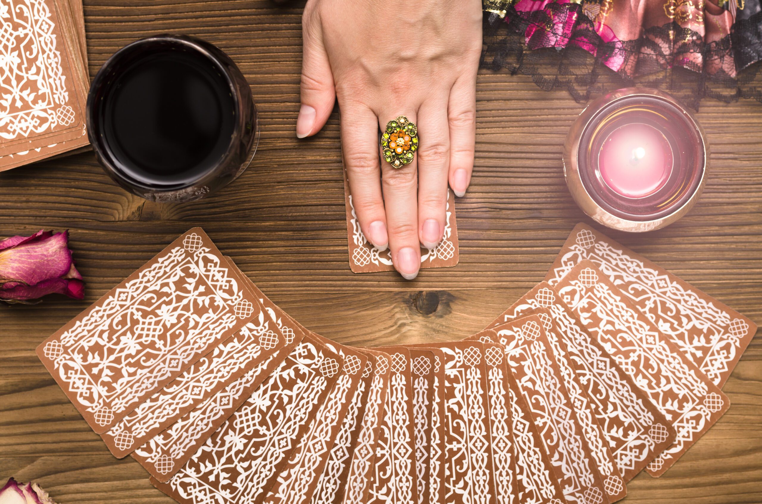 Fortune teller female hands and tarot cards on wooden table