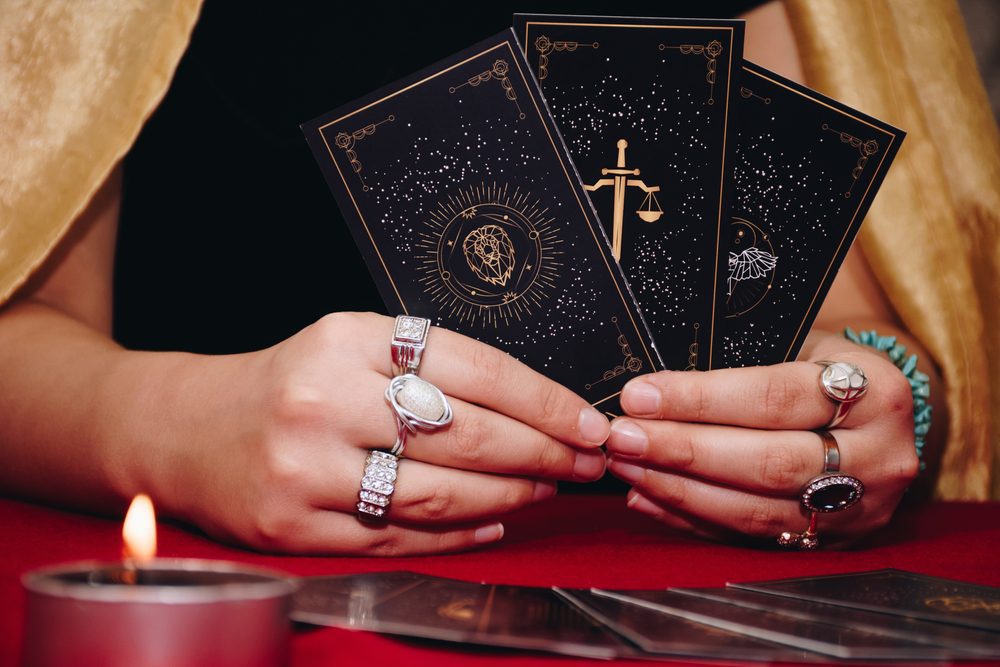 A person holding tarot cards performing clairvoyant readers