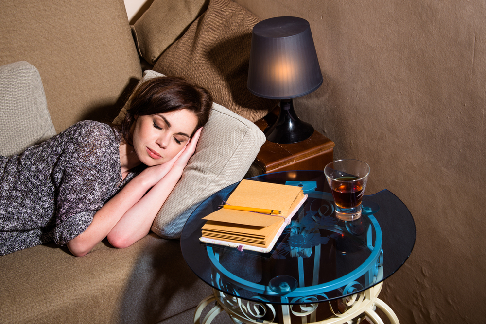 Girl sleeping on a pillow, standing next to the table and lamp
